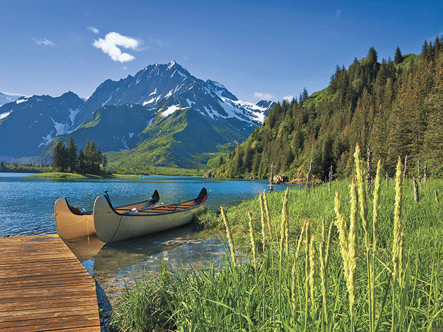 canoes on lake in front of mountain